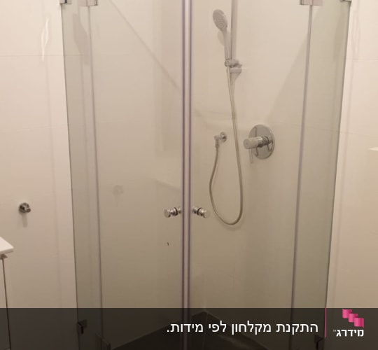 מקלחון זכוכית פינתי שקוף מותקן בחדר רחצה